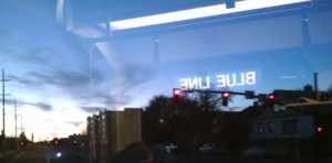 Picture taken from train, "blue line" reflected in reverse in the window.